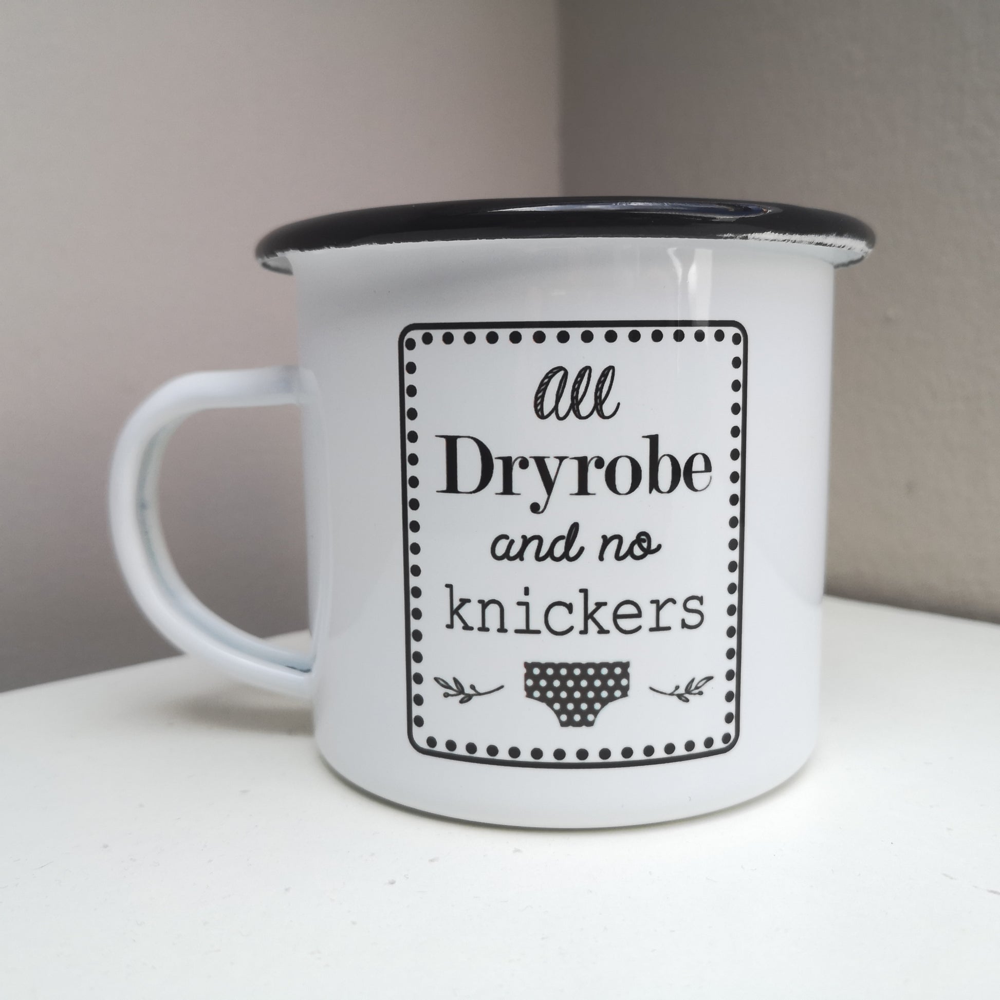 A white steel enamel mug with ALL DRYROBE AND NO KNICKERS on it in black and white text.  And black and white spotty knickers.  