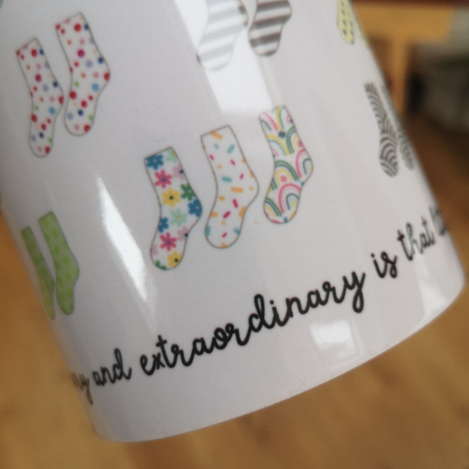 A close up of the mug that celebrates Down Syndrome and how it is the result of having 47 chromosomes instead of 46.  Each colourful pair of socks represents the 44 chromosomes we all have, but pair 21 has 3 socks instead of 2.